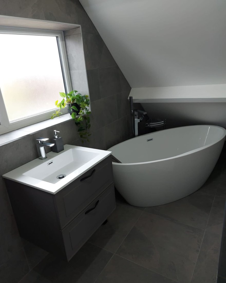 Modern loft bathroom with a freestanding bath and grey vanity