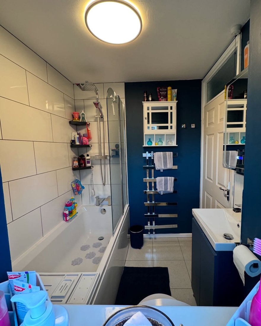 Bathroom refit with a navy feature wall, white tiling and heated towel rail