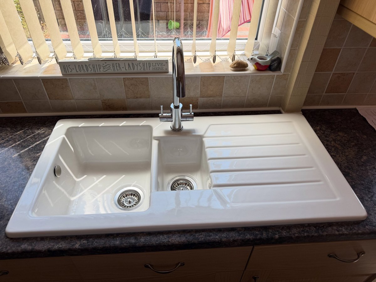 New white kitchen sink and drainer with a chrome tap