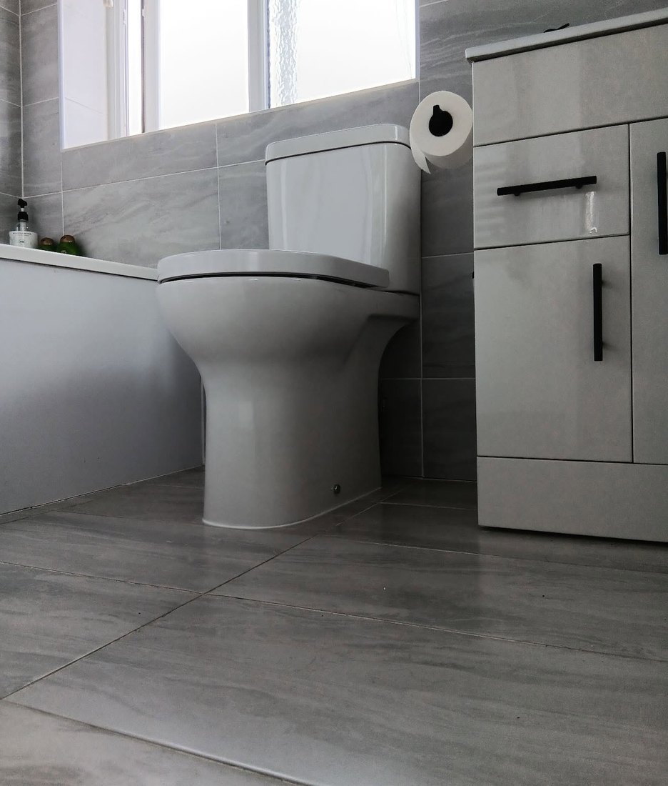 New close-coupled toilet fitted in a grey bathroom